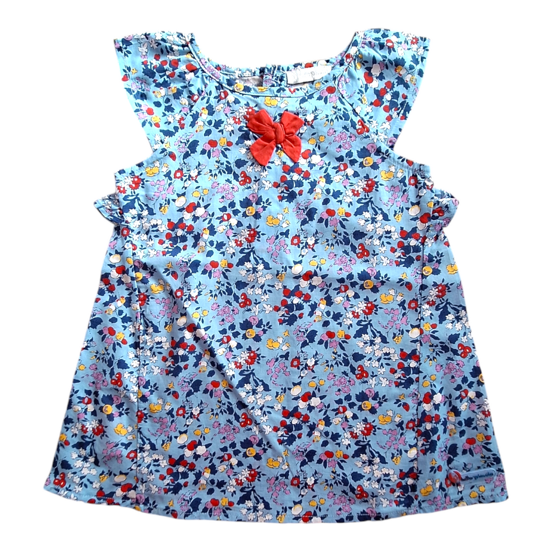 Tutto Piccolo light dress, size 74CM. The dress has a light blue background with a floral print in multiple colors and a red bow at the neckline. It has short, ruffled sleeves and a buttoned-up back.